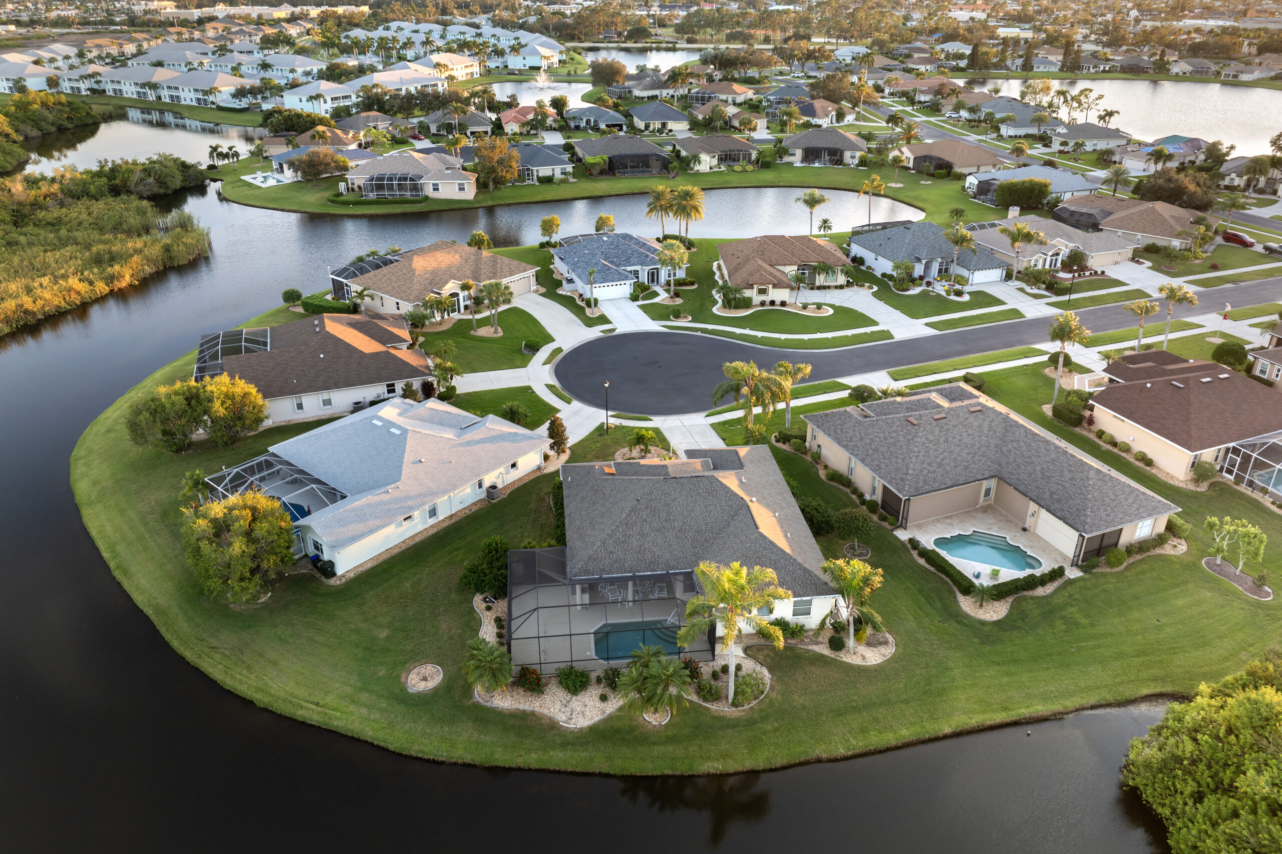 Waterfront single family homes in Florida residential area at sunset. Real estate development in American suburbs